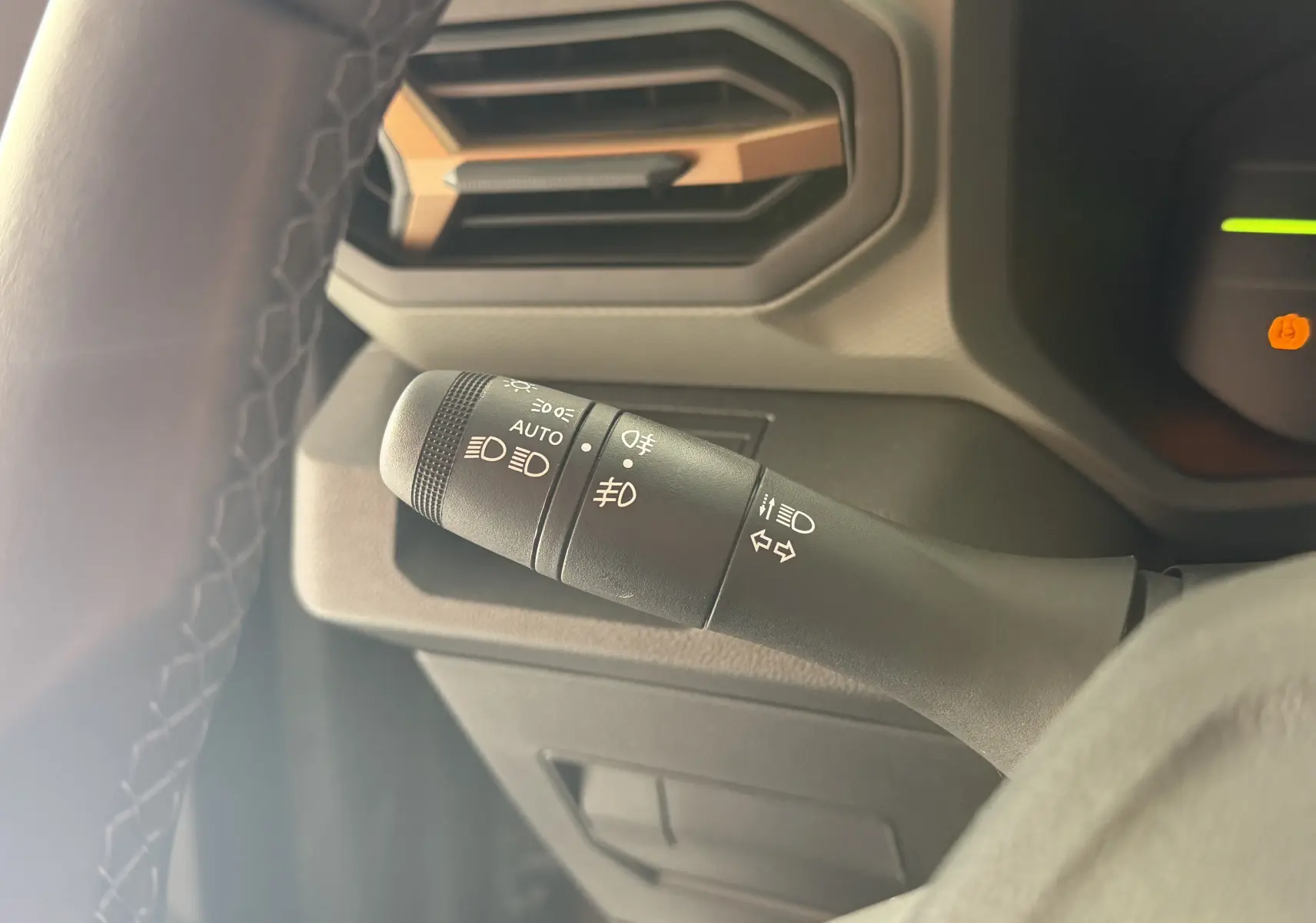 Gros plan sur la commande des feux à gauche du volant dans l’habitacle du Dacia Duster Hybrid 155 Extreme 2026.