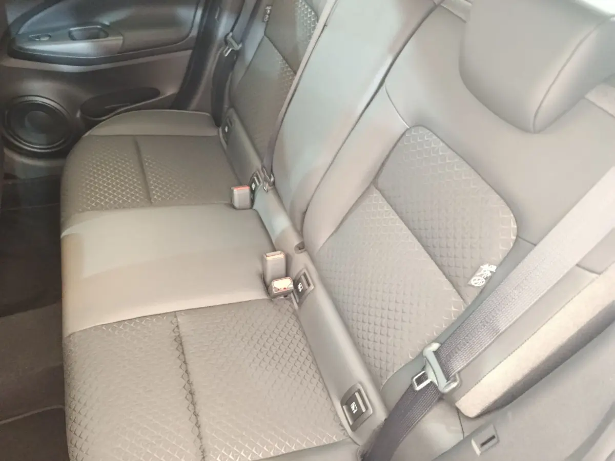 Vue rapprochée de la banquette arrière en cuir gris du Nissan Juke 2025, avec ceintures et fixation Isofix visibles.