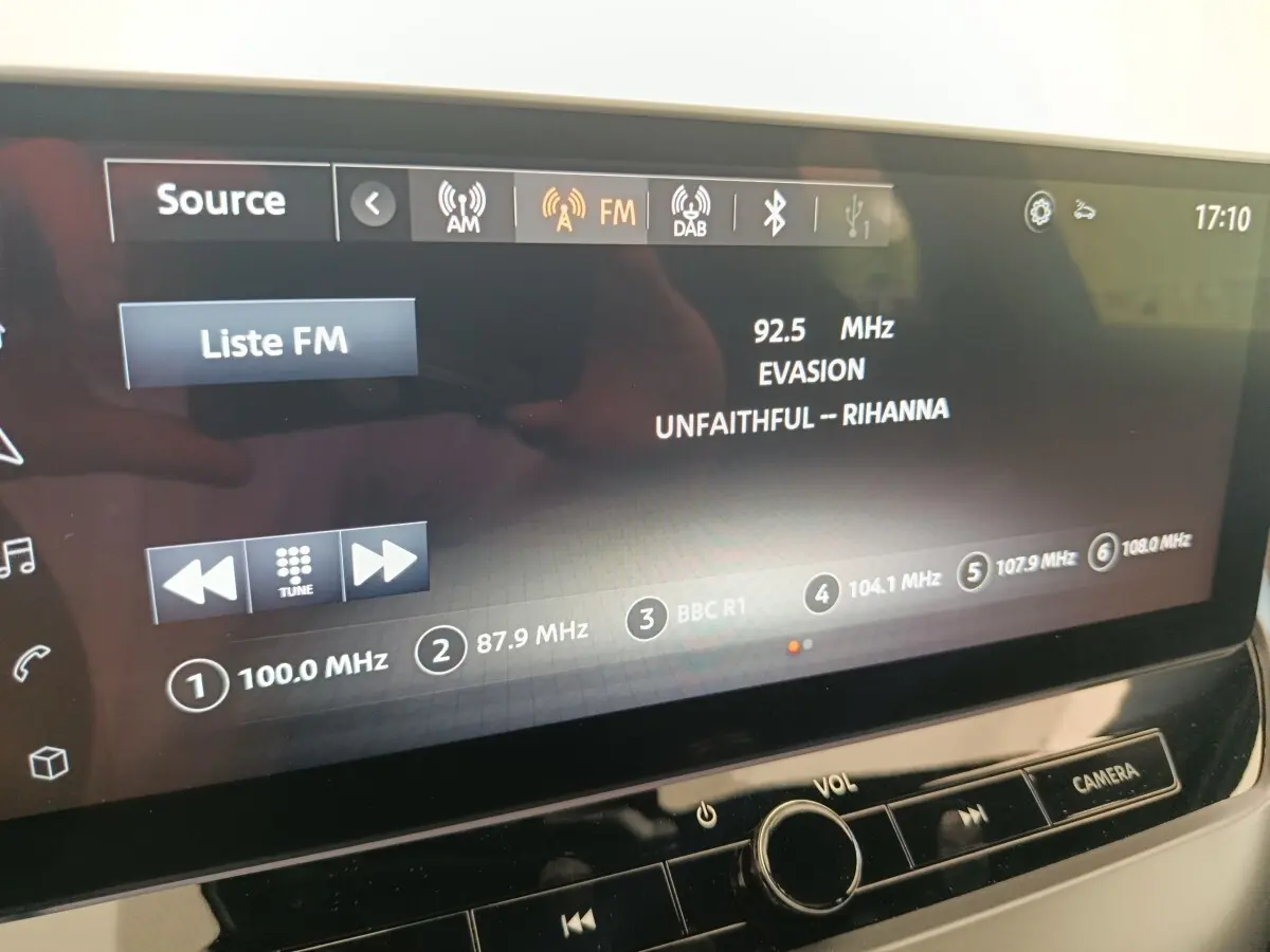 Écran tactile central du Nissan Juke bleu 2025 affichant la radio FM avec station 92.5 MHz et titre musical visible.