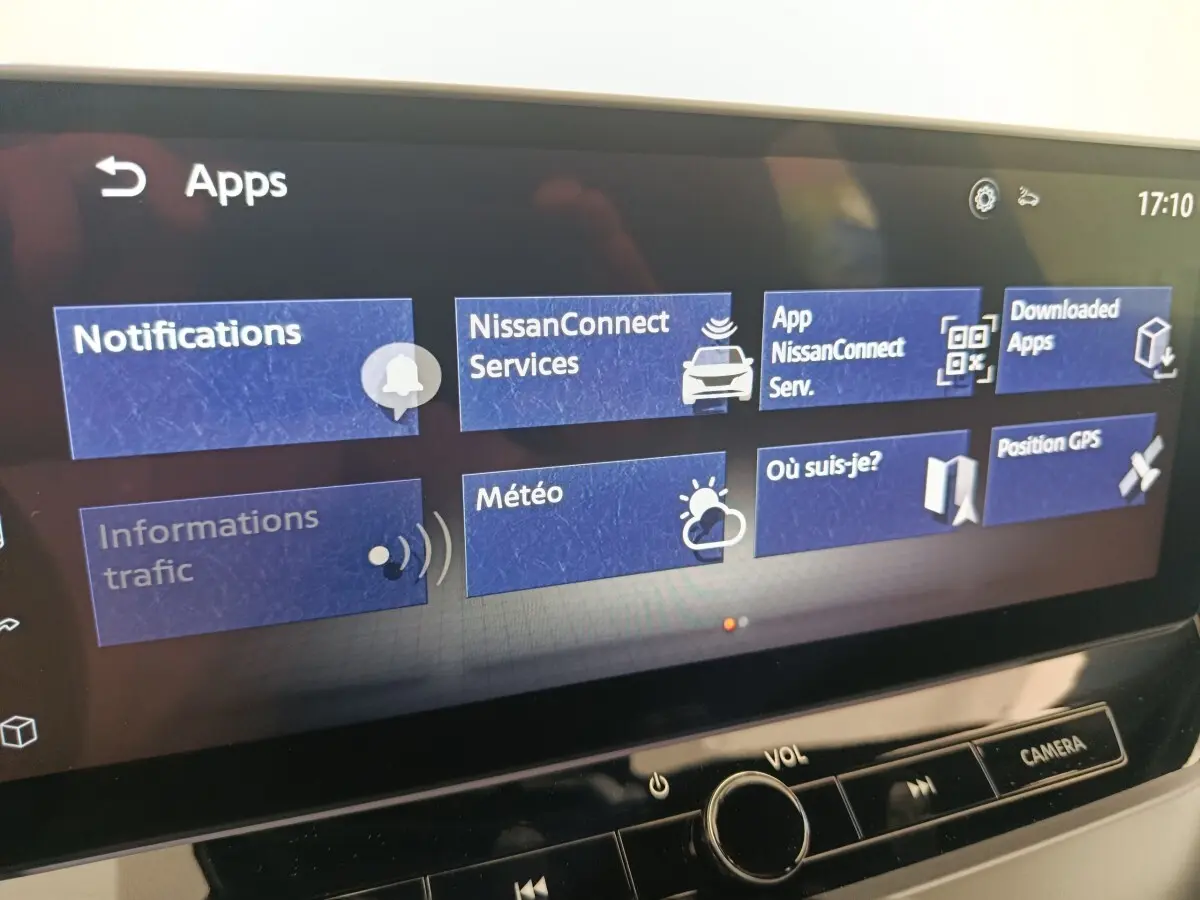 Écran tactile central du Nissan Juke bleu 2025 affichant le menu des applications connectées.