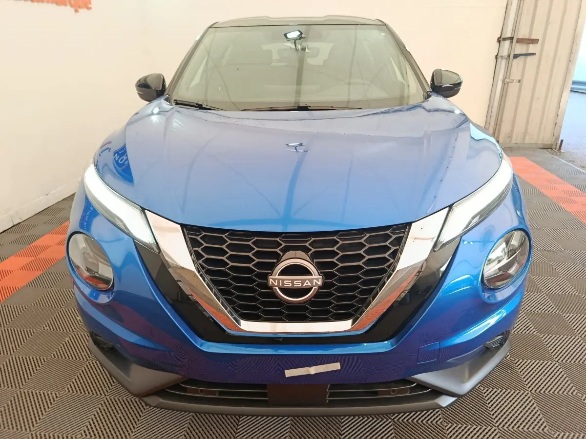 Vue avant d'un Nissan Juke bleu 2025 avec calandre en nid d'abeille et phares LED distinctifs.