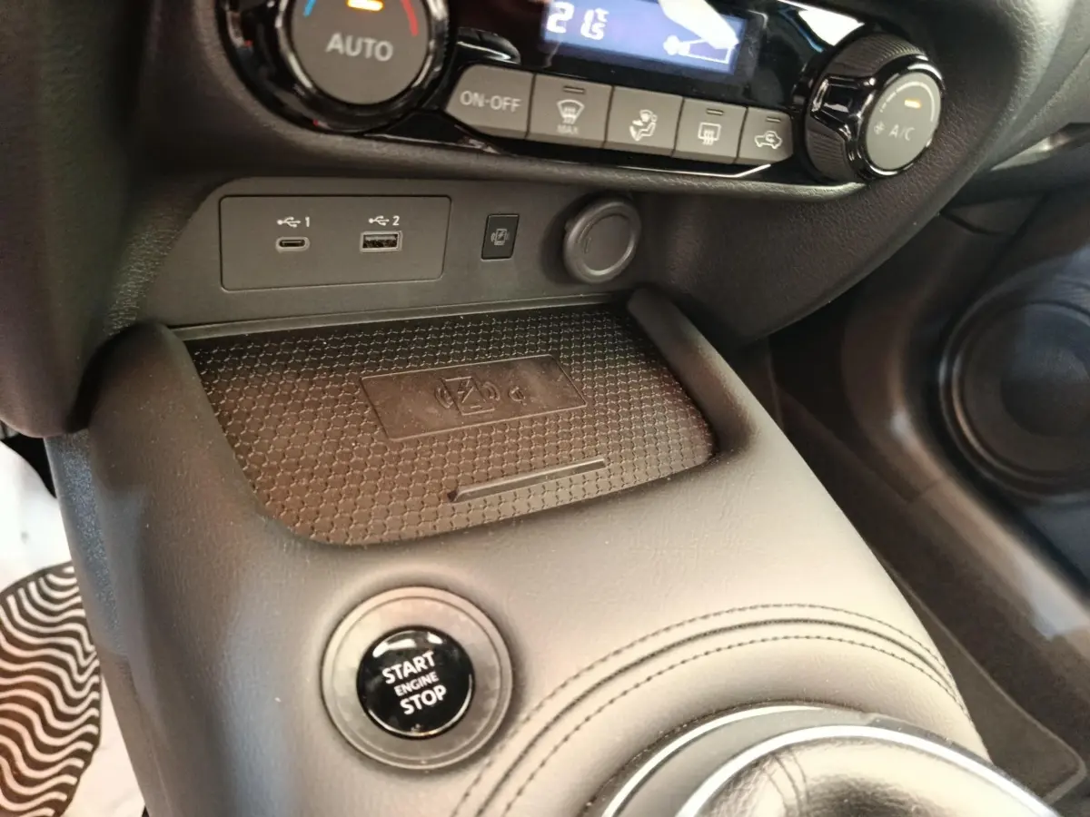 Gros plan intérieur sur la console centrale noire du Nissan Juke 2025, avec bouton Start/Stop et ports USB visibles.