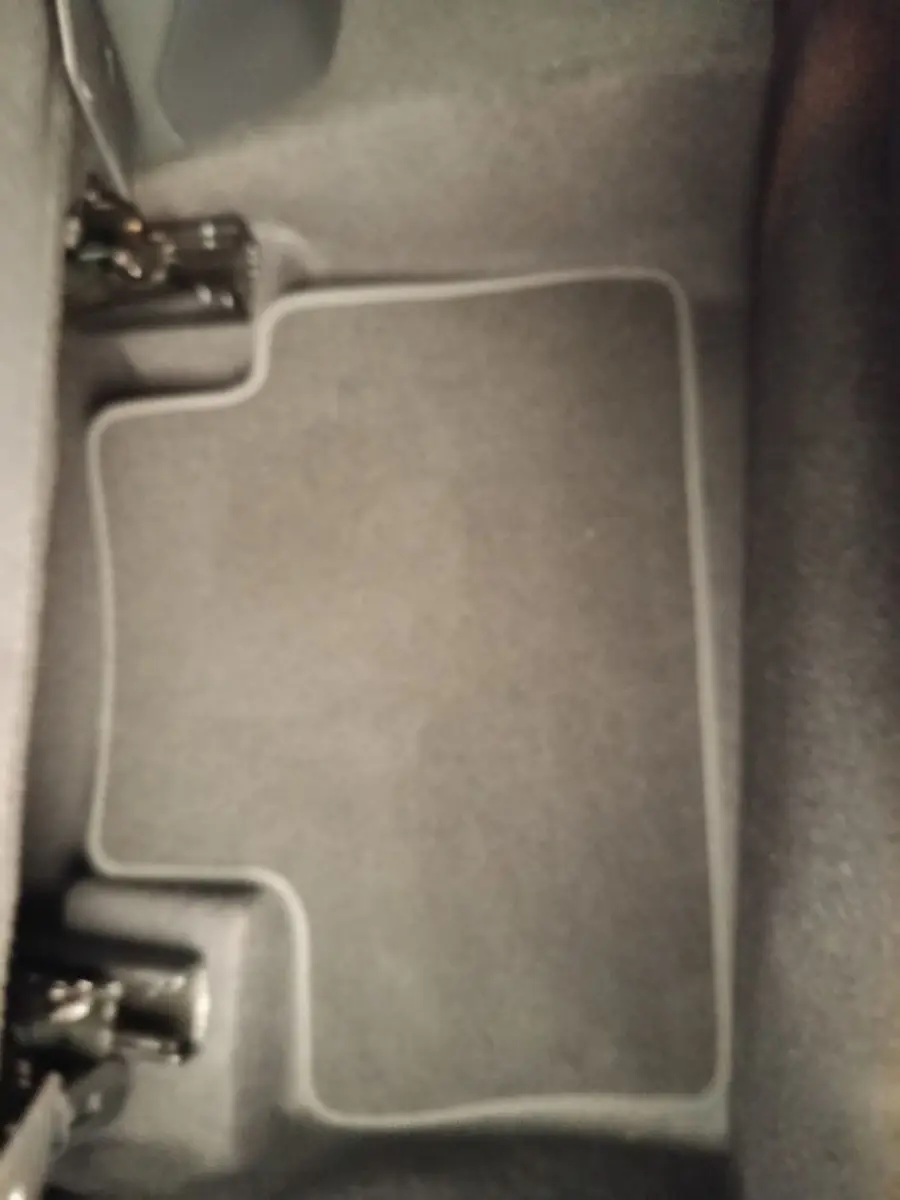 Vue rapprochée du tapis de sol gris foncé à l'avant droit du Nissan Juke DIG-T 114 BVM6 N-Connecta 2025.