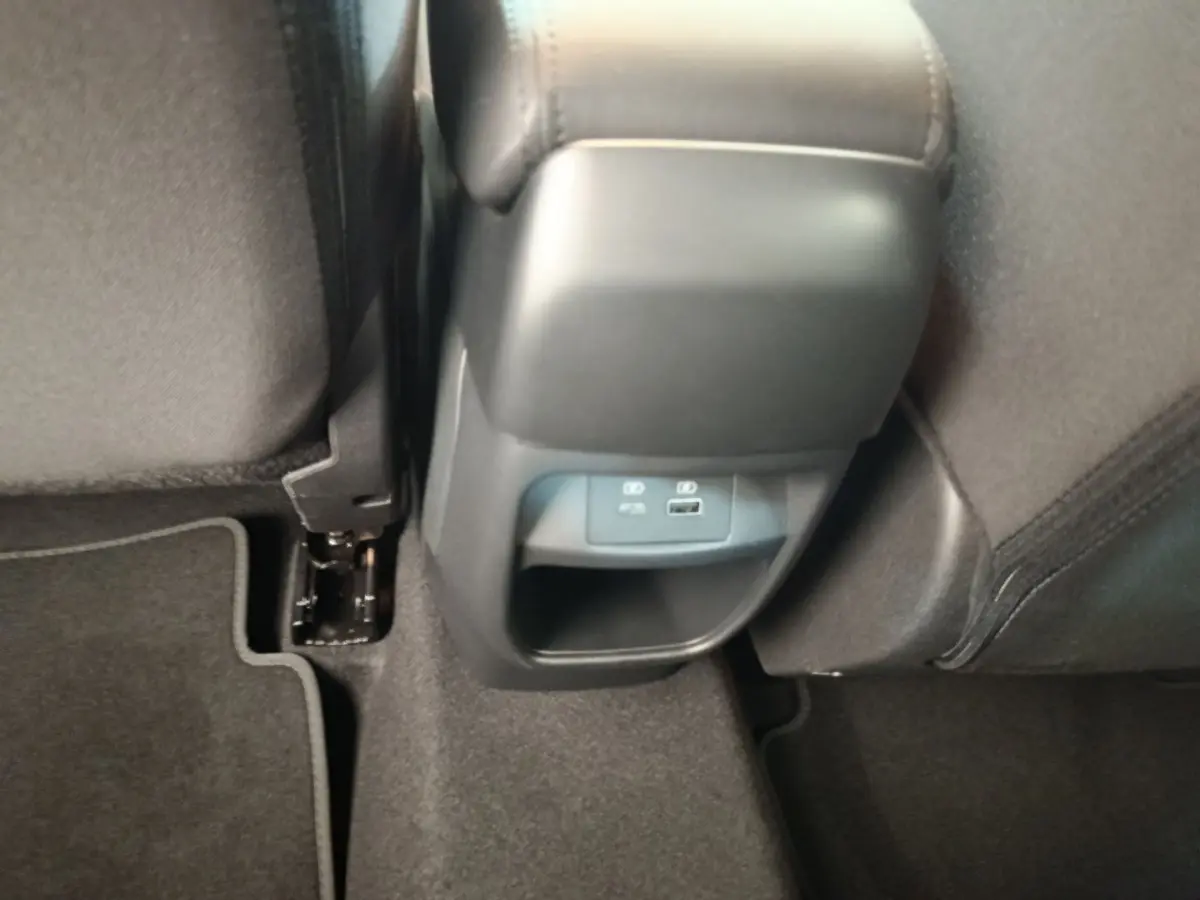 Prise USB et port 12V visibles sous l'accoudoir central arrière du Nissan Juke DIG-T 114 BVM6 N-Connecta 2025.