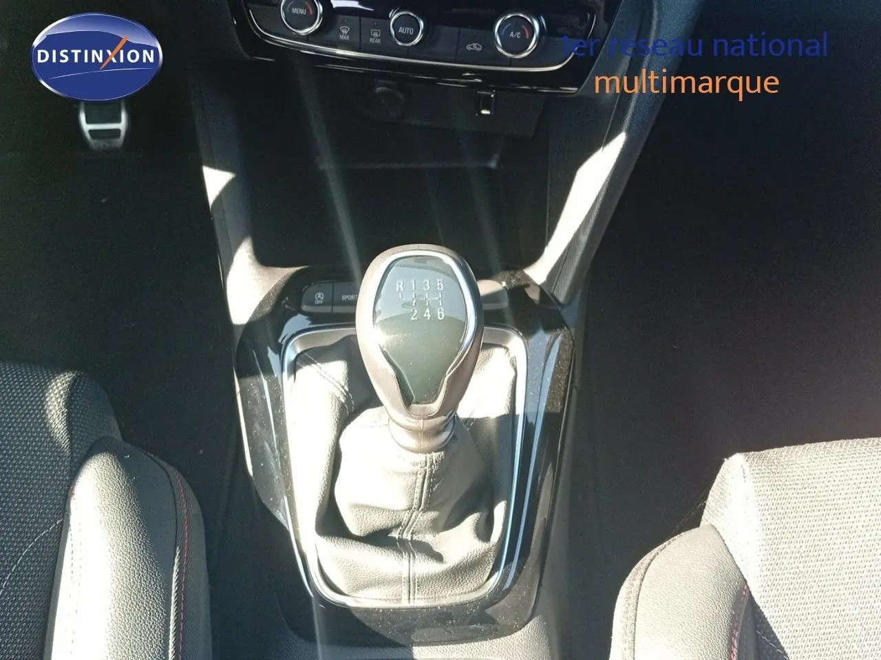 Le levier de vitesses manuel de l'Opel Corsa 1.2 Turbo 100ch, vu de dessus, avec sellerie noire et console brillante.