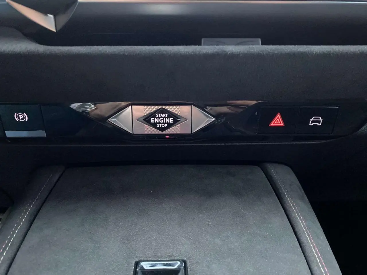 Détail du tableau de bord du DS4 2022 avec bouton start/stop central et commandes électroniques sur fond noir.