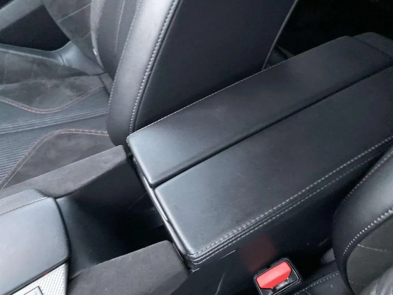 Gros plan sur l'accoudoir central noir et les sièges en cuir noir du DS4 Gris Platinium 2022, version Performance Line +.