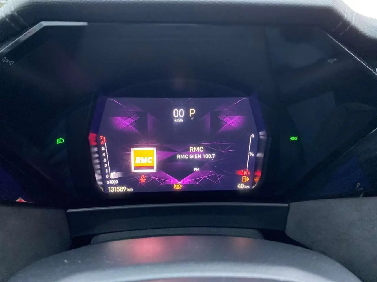 Tableau de bord numérique du DS4 2022 en gros plan, affichant la radio RMC et l'indicateur de vitesse à 0 km/h.