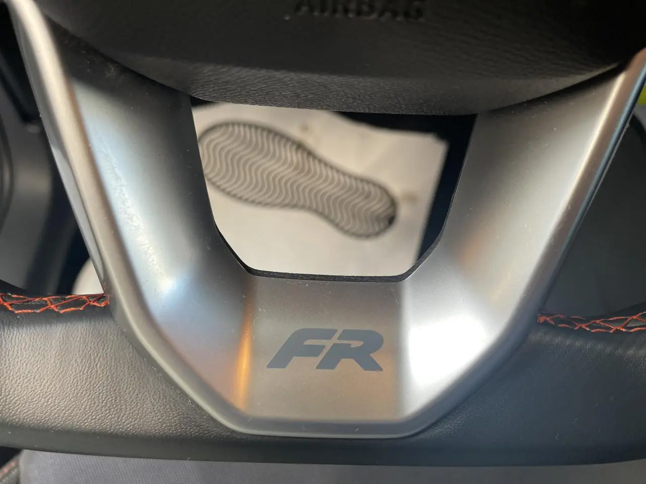 Gros plan sur le volant sport cuir noir avec logo FR et surpiqûres rouges du SEAT Arona 2024.