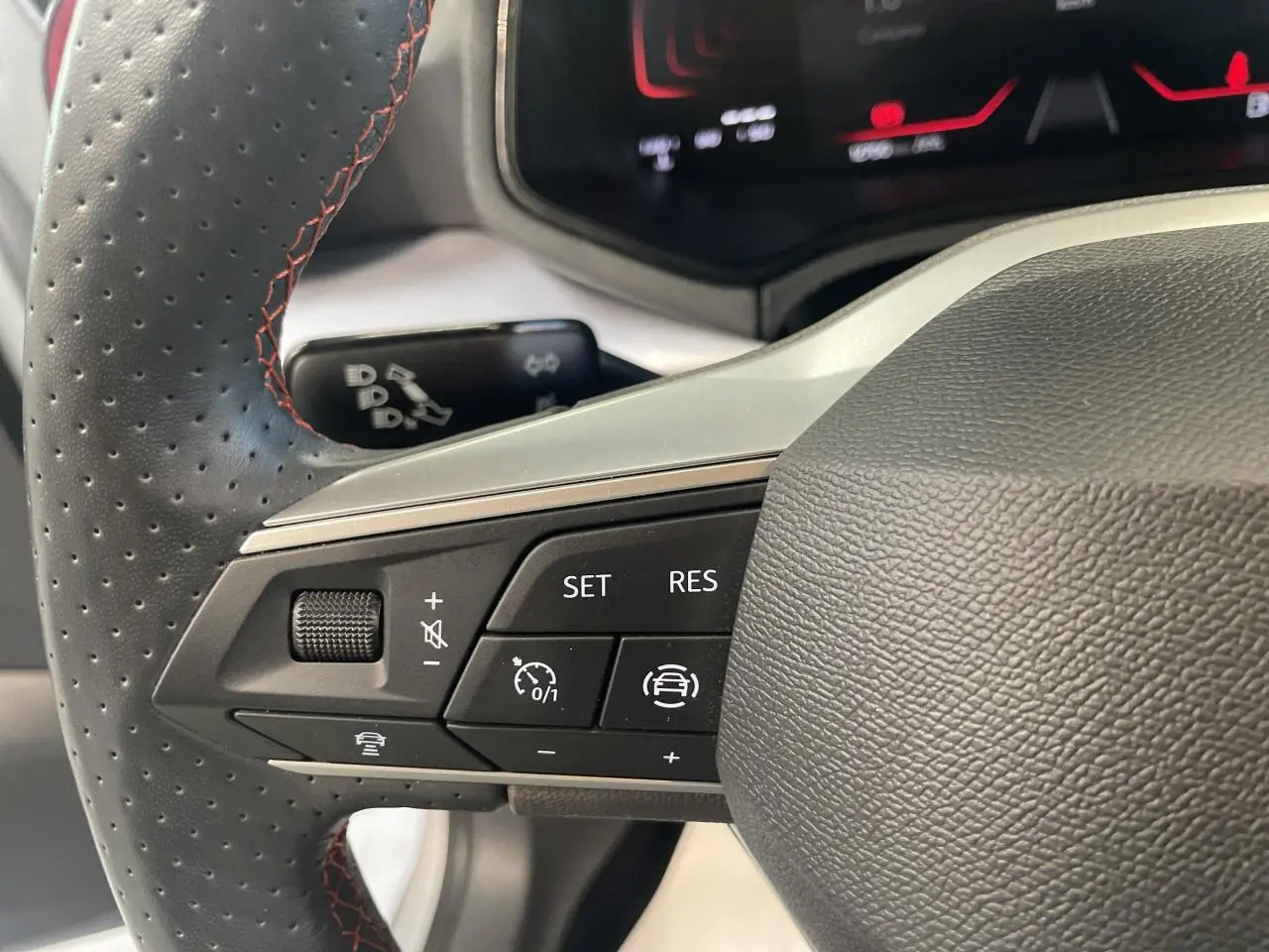 Gros plan sur le volant cuir perforé avec commandes multifonctions du SEAT Arona 2024, finition FR, intérieur noir.