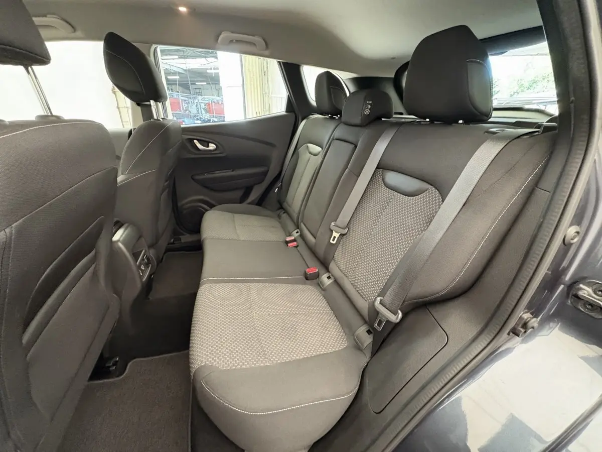 Vue intérieure côté droit montrant la banquette arrière gris foncé du Renault Kadjar 2019 avec ceinture de sécurité et appuie-têtes.