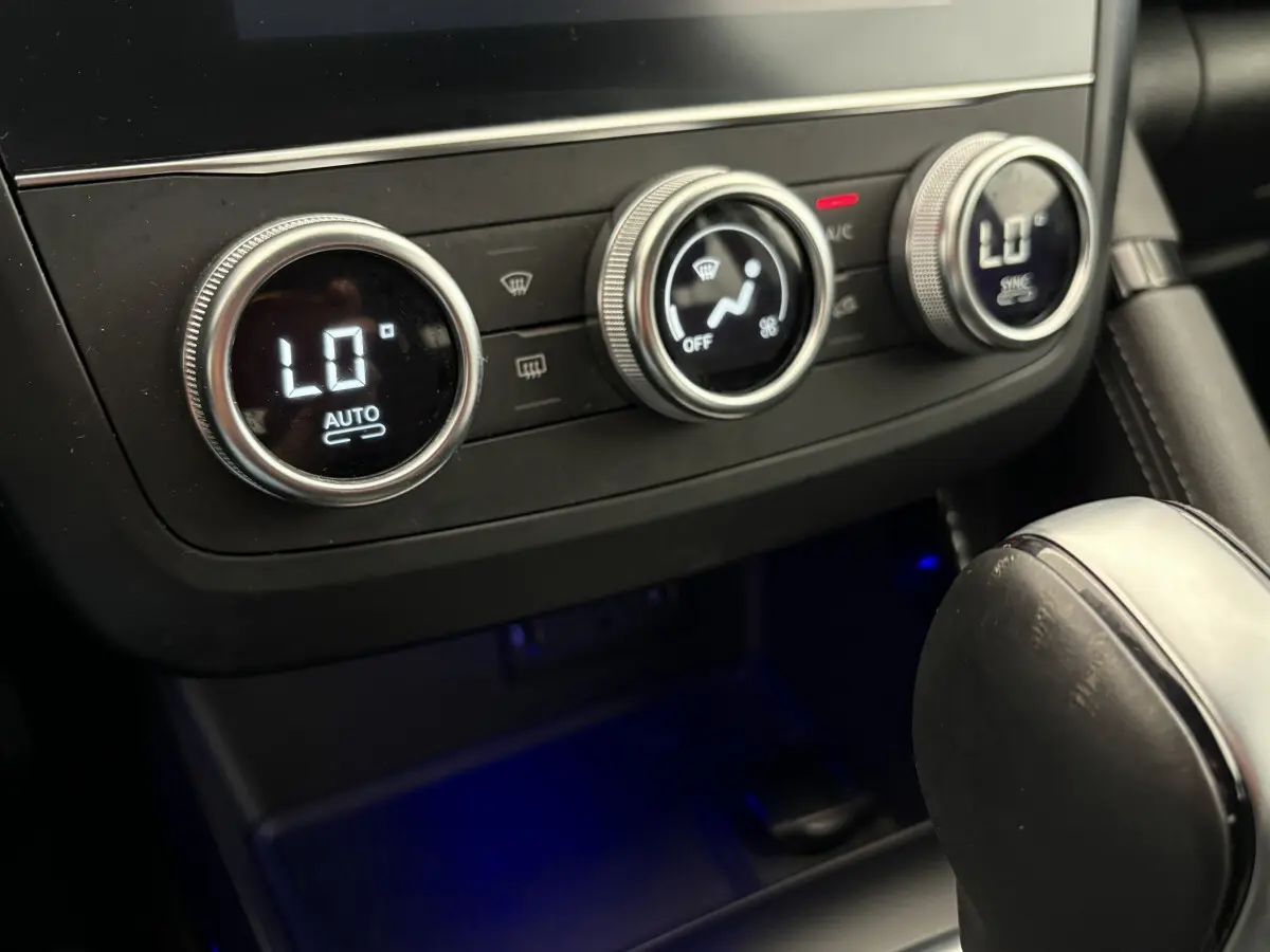 Détail de la commande de climatisation digitale avec réglages circulaires dans le Renault Kadjar gris foncé, vue intérieure rapprochée.