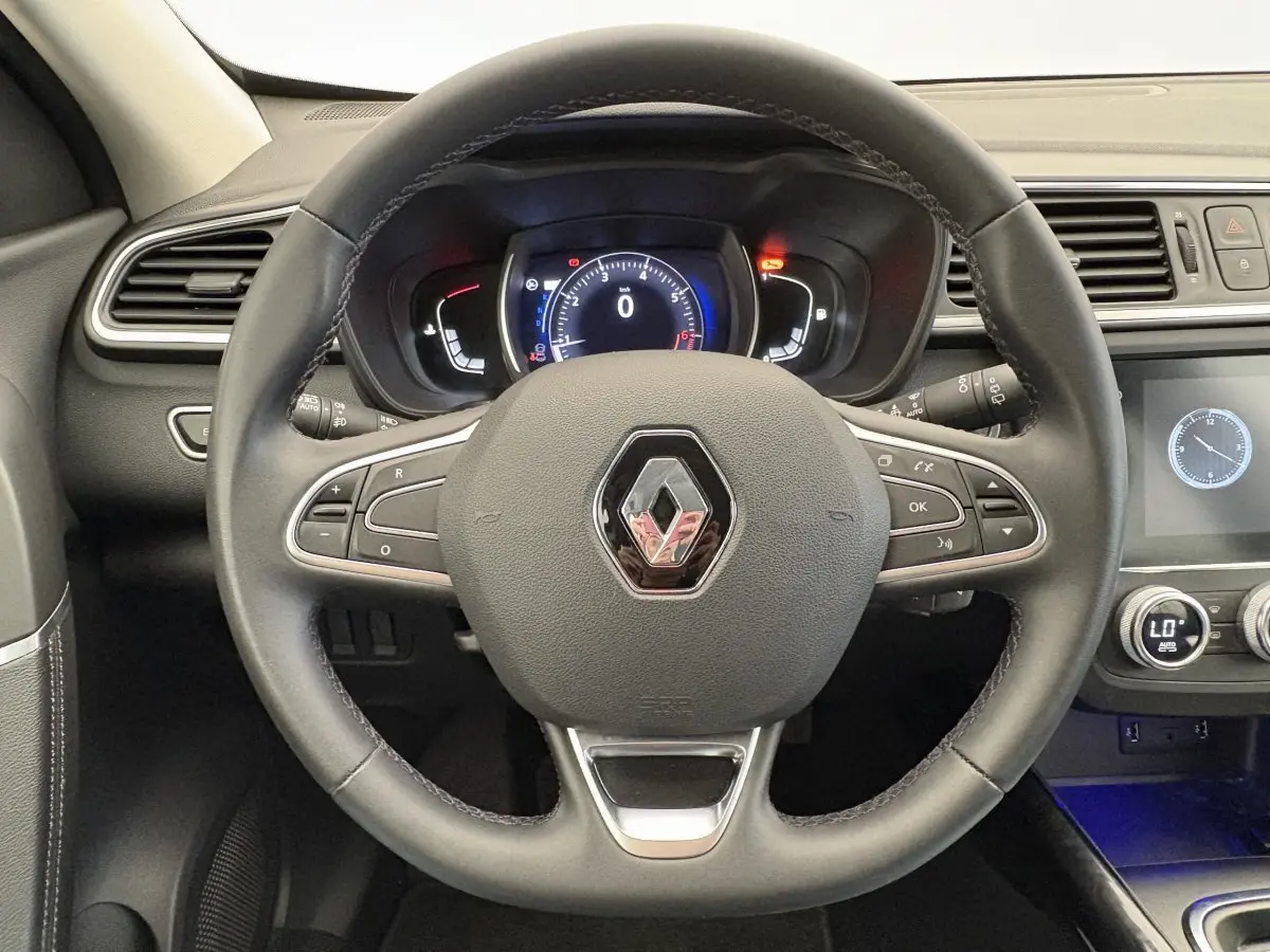 Vue rapprochée du volant cuir noir avec logo Renault et tableau de bord numérique du Renault Kadjar 2019.