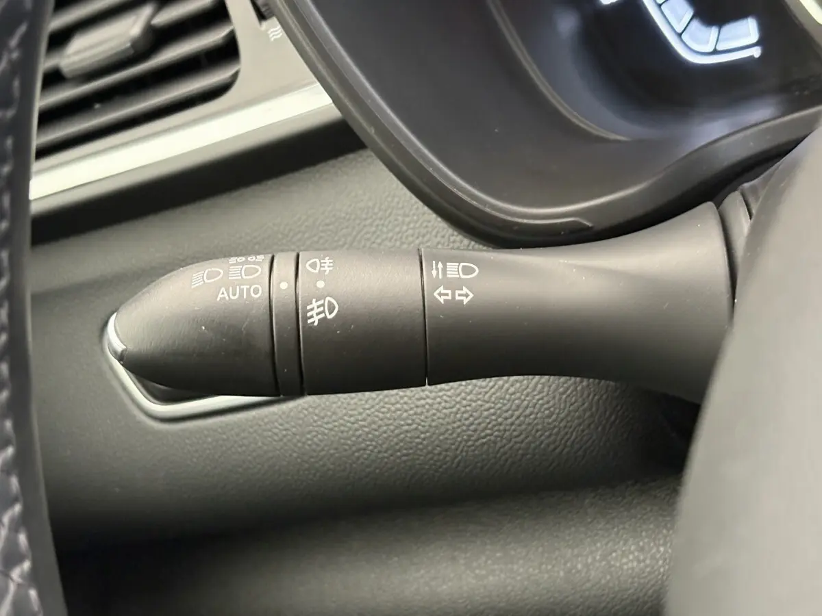 Gros plan sur la commande des phares et clignotants du Renault Kadjar gris foncé, intérieur tableau de bord.
