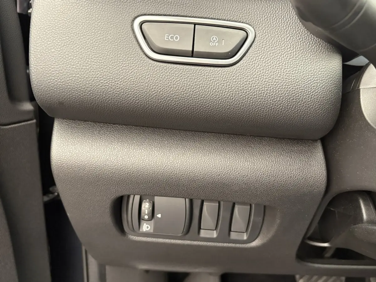 Gros plan sur les commandes de tableau de bord gris foncé du Renault Kadjar Intens 2019, avec bouton ECO et réglage phares.