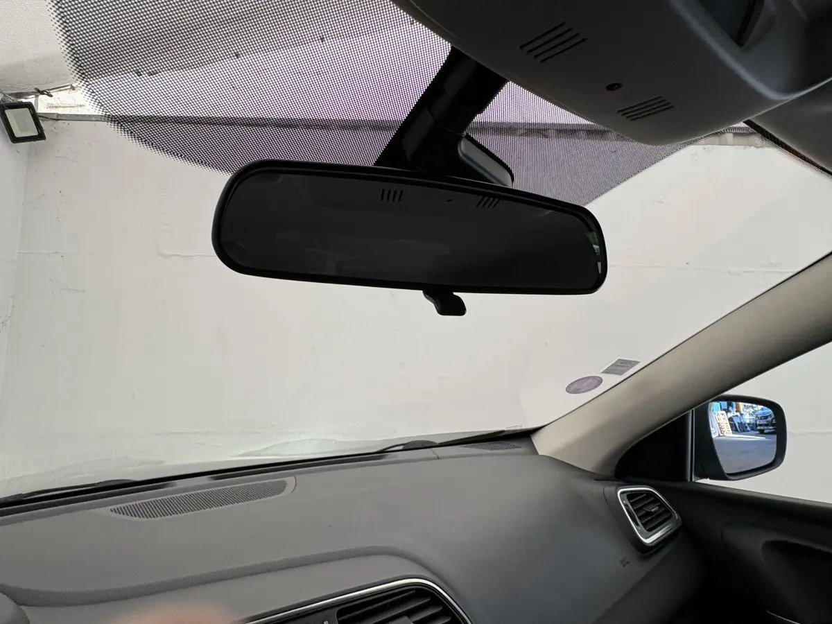 Vue intérieure du tableau de bord et rétroviseur central du Renault Kadjar gris foncé, côté passager visible.