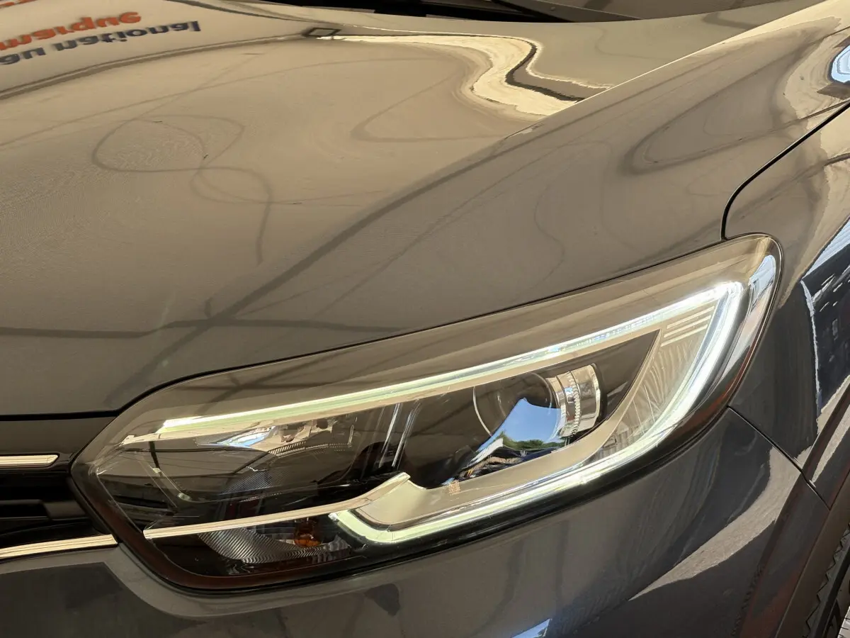 Gros plan sur le phare avant droit du Renault Kadjar gris foncé, mettant en valeur ses feux LED modernes.