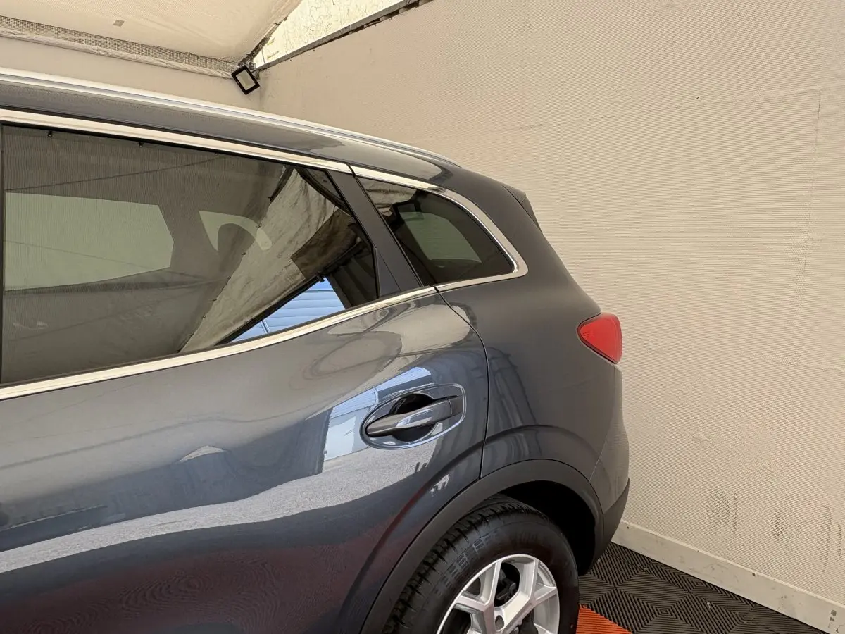 Vue côté arrière droit du Renault Kadjar Intens gris foncé, mettant en valeur la porte et le feu arrière.