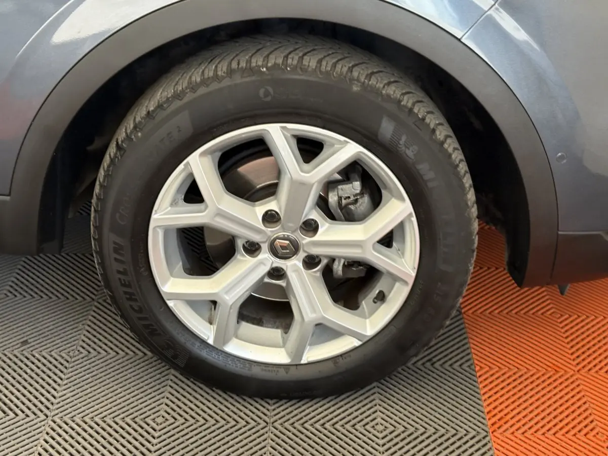 Gros plan sur la roue avant gauche gris foncé du Renault Kadjar Intens avec jante alliage à cinq branches doubles.