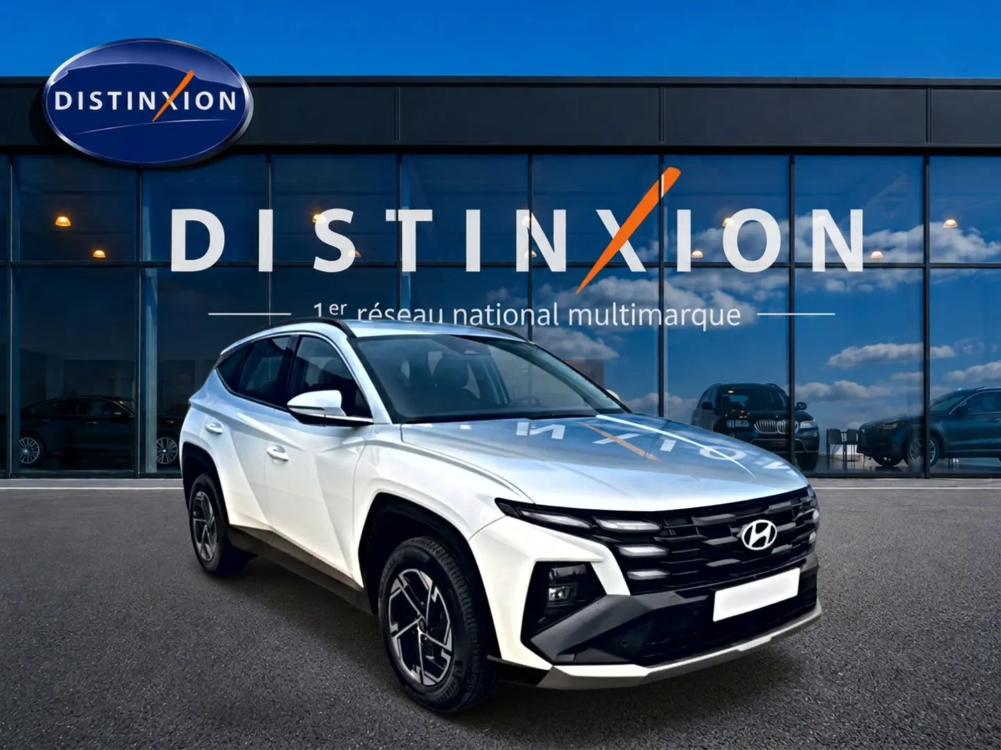 Hyundai Tucson blanc 2026 en 3/4 avant droit, avec calandre noire et jantes alliage 17 pouces.
