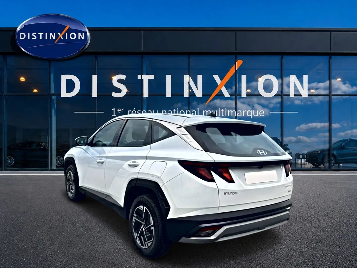 Vue 3/4 arrière droite du Hyundai Tucson blanc 2026 avec jantes alliage et feux arrière LED distinctifs.