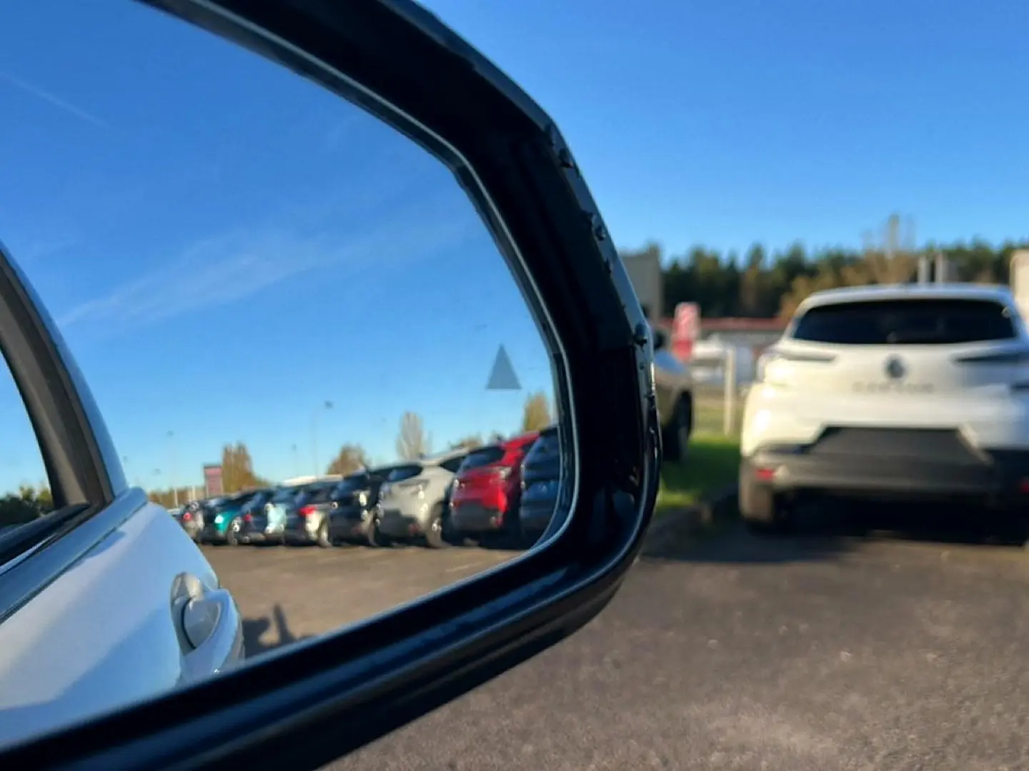 Vue latérale droite d'une BMW Série 1 blanche alpin, avec jantes bicolores en Y visibles au soleil.