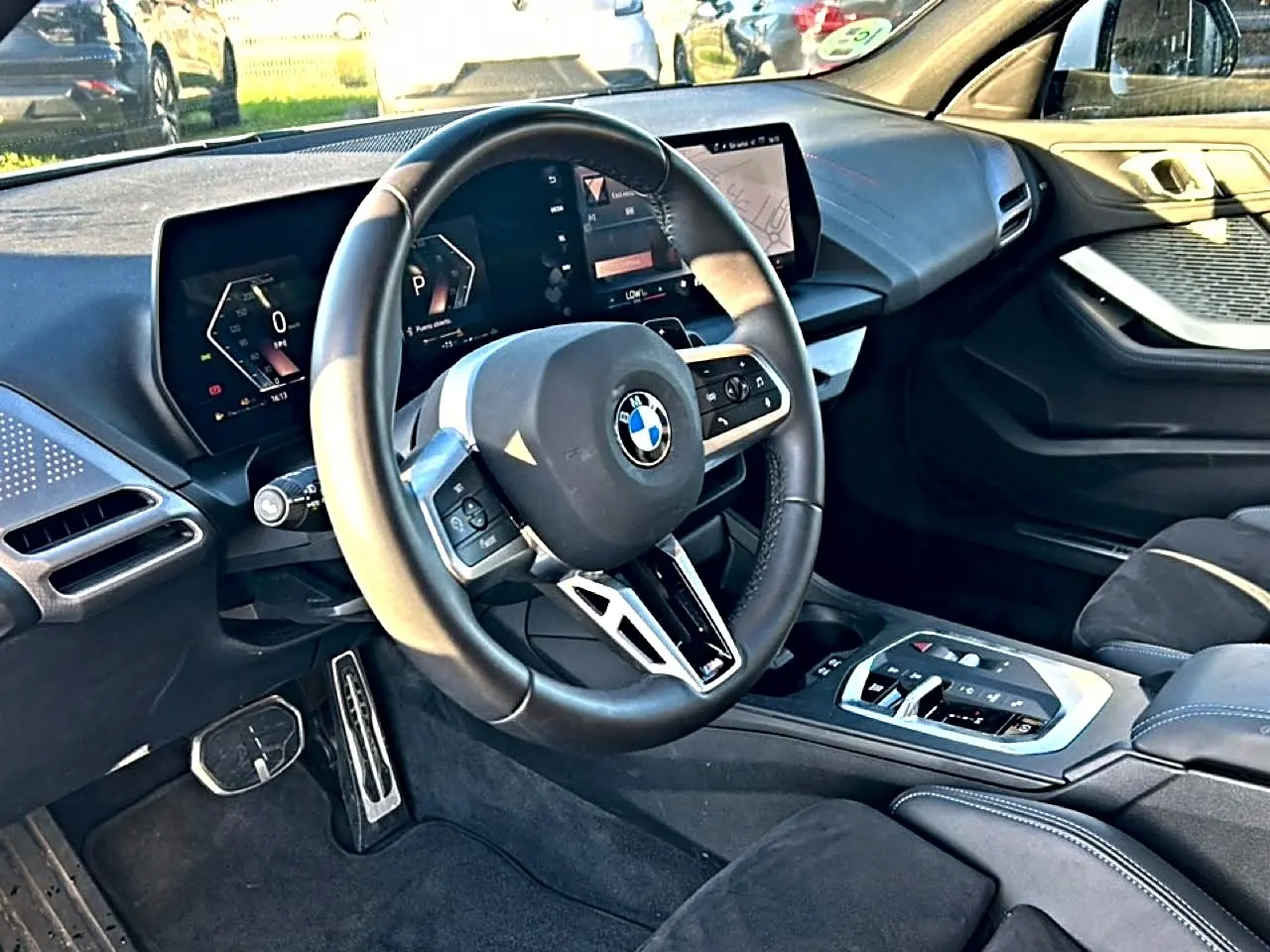 Vue intérieure côté conducteur de la BMW Série 1 2025 avec volant multifonction et tableau de bord digital.