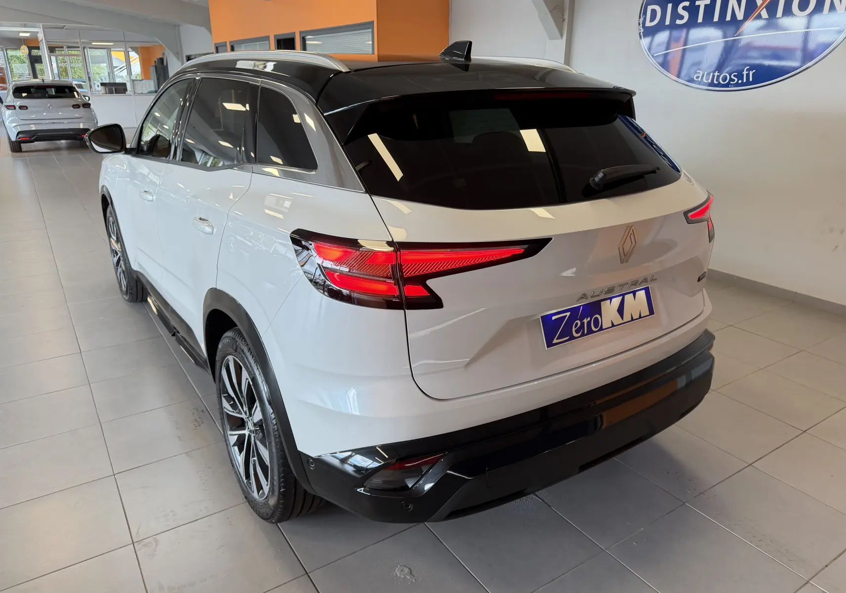 Renault Austral E-Tech 200 blanc toit noir, vue 3/4 arrière droit, jantes alliage 19 pouces et feux LED distinctifs.