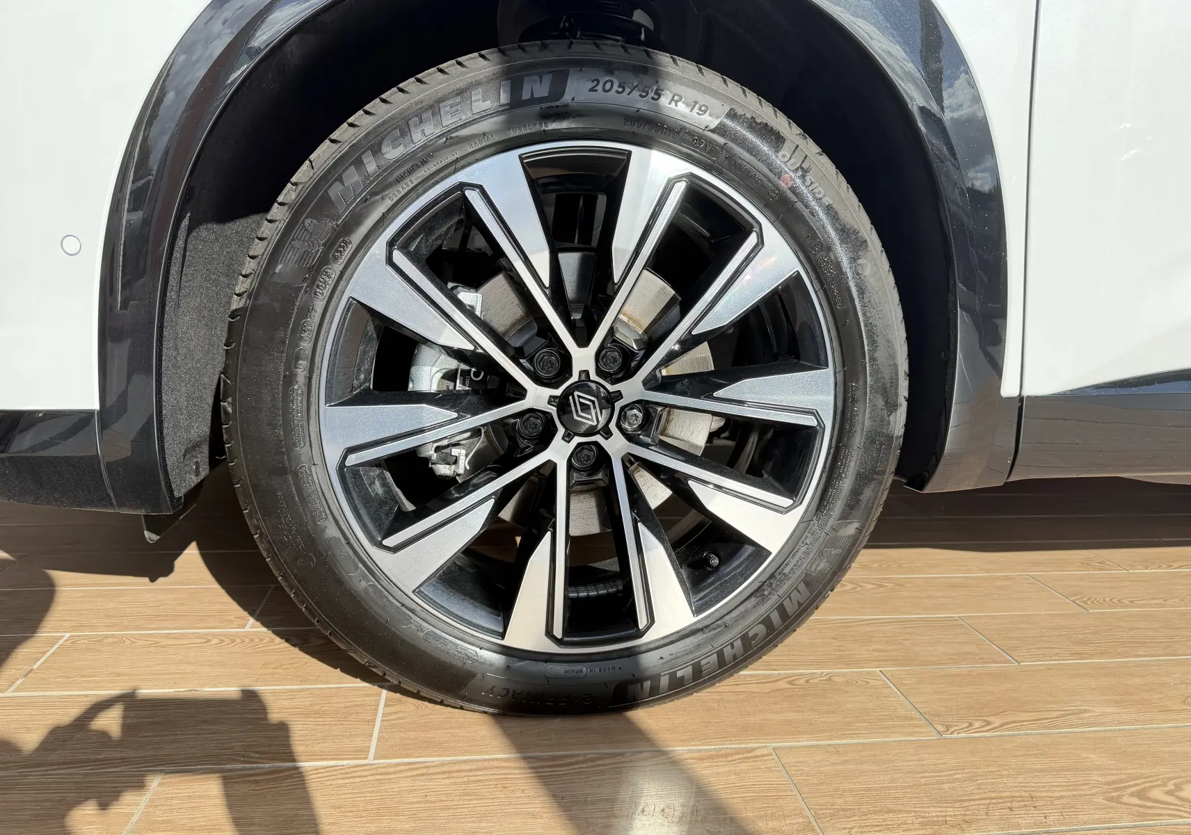 Gros plan sur la jante alliage 19 pouces bicolore du Renault Austral E-Tech blanc toit noir, avec pneu Michelin.