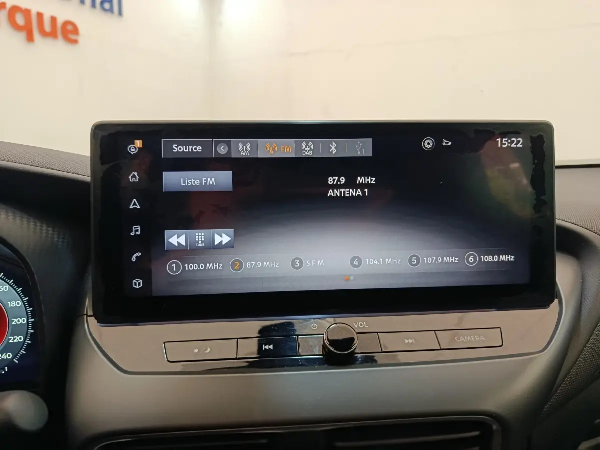 Écran tactile central affichant la radio FM dans l'habitacle du Nissan Juke gris clair, vue de face.