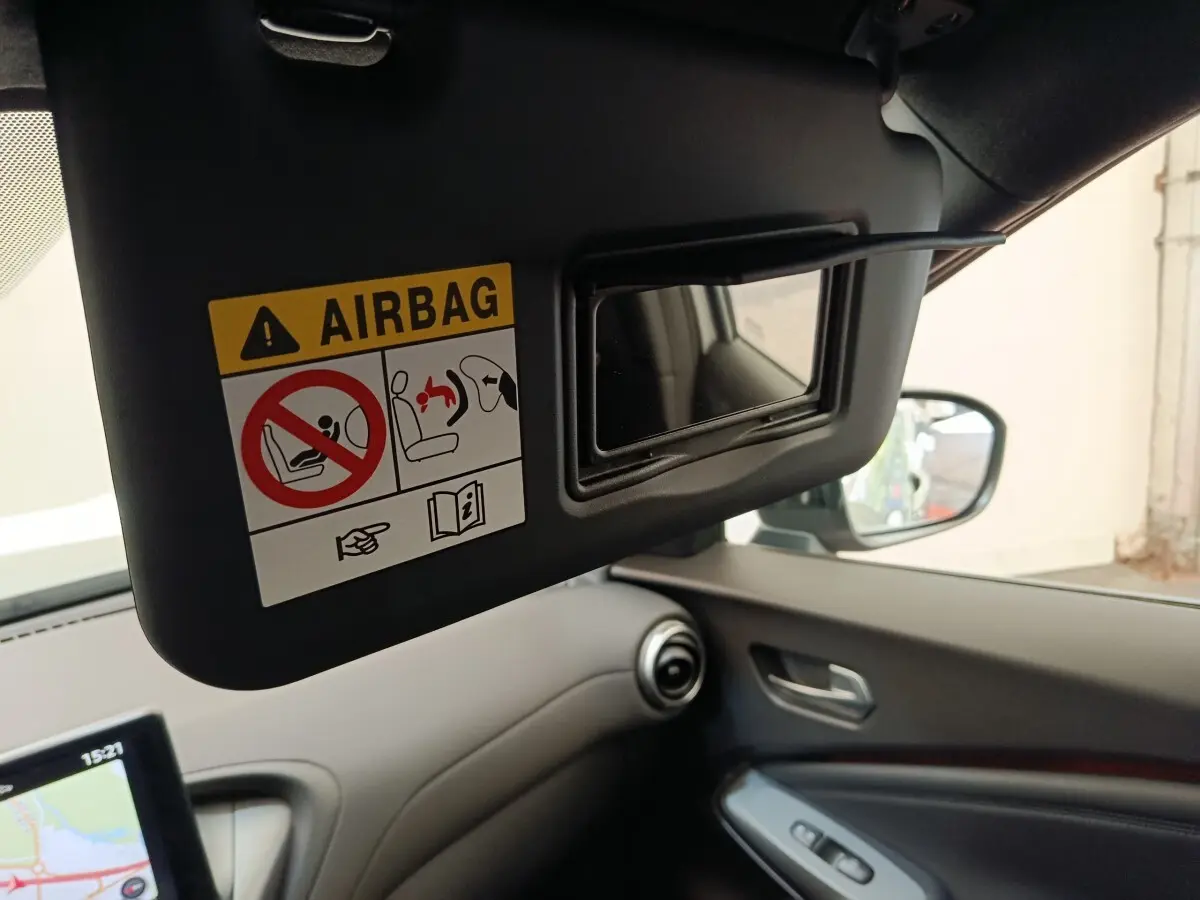 Vue intérieure côté conducteur du Nissan Juke gris clair 2025, avec pare-soleil ouvert et miroir intégré visible.