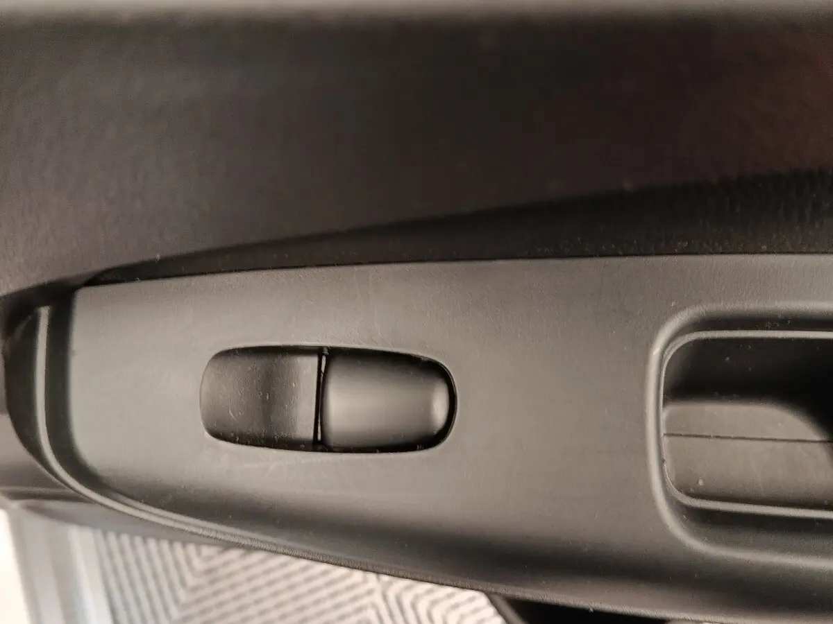 Détail du bouton de réglage du siège côté conducteur dans l'habitacle du Nissan Juke gris clair 2025.