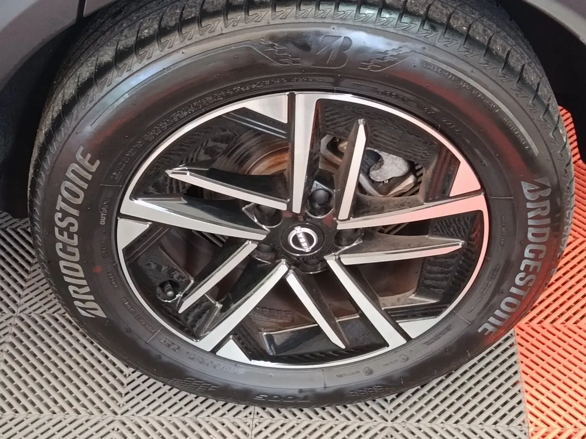 Gros plan sur la jante alliage bicolore et pneu Bridgestone du Nissan Juke gris clair, côté roue avant.