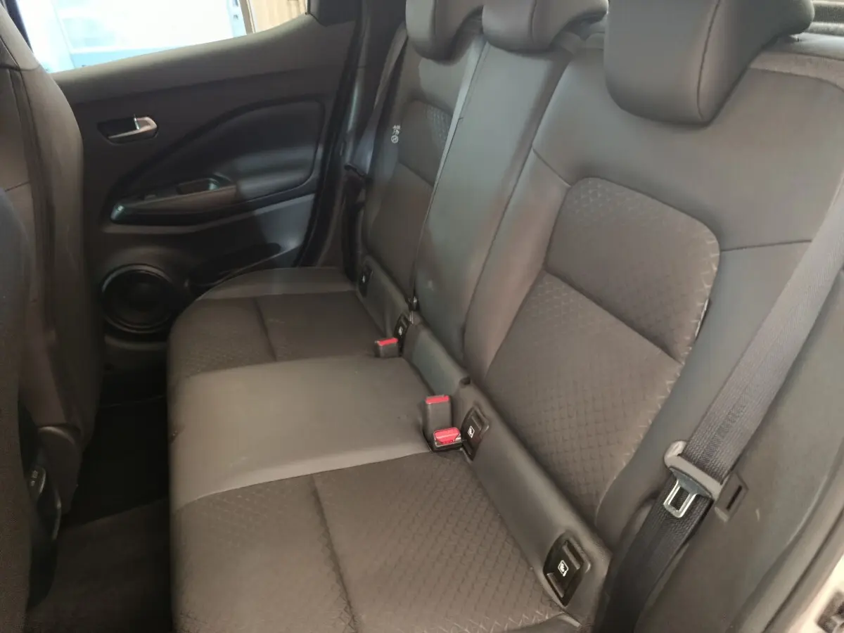 Vue intérieure côté droit des sièges arrière noirs du Nissan Juke 2025, avec ceintures et ancrages Isofix visibles.