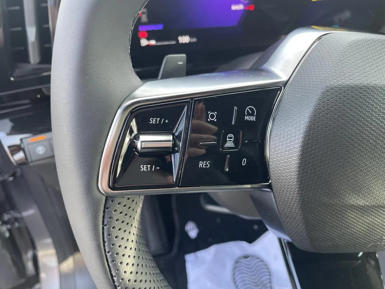 Gros plan sur les commandes de régulateur de vitesse au volant textile refined de la Renault Rafale 2025.