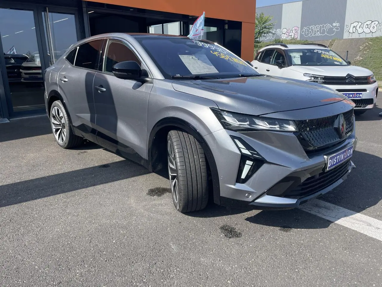 Renault Rafale gris avec toit noir en 3/4 avant droit, calandre noire et jantes alliage visibles.