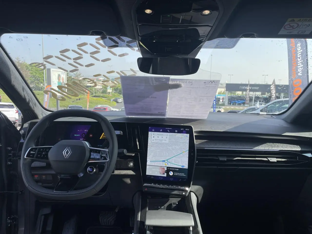 Vue intérieure avant du Renault Rafale 2025, tableau de bord noir avec écran tactile vertical affichant la navigation.