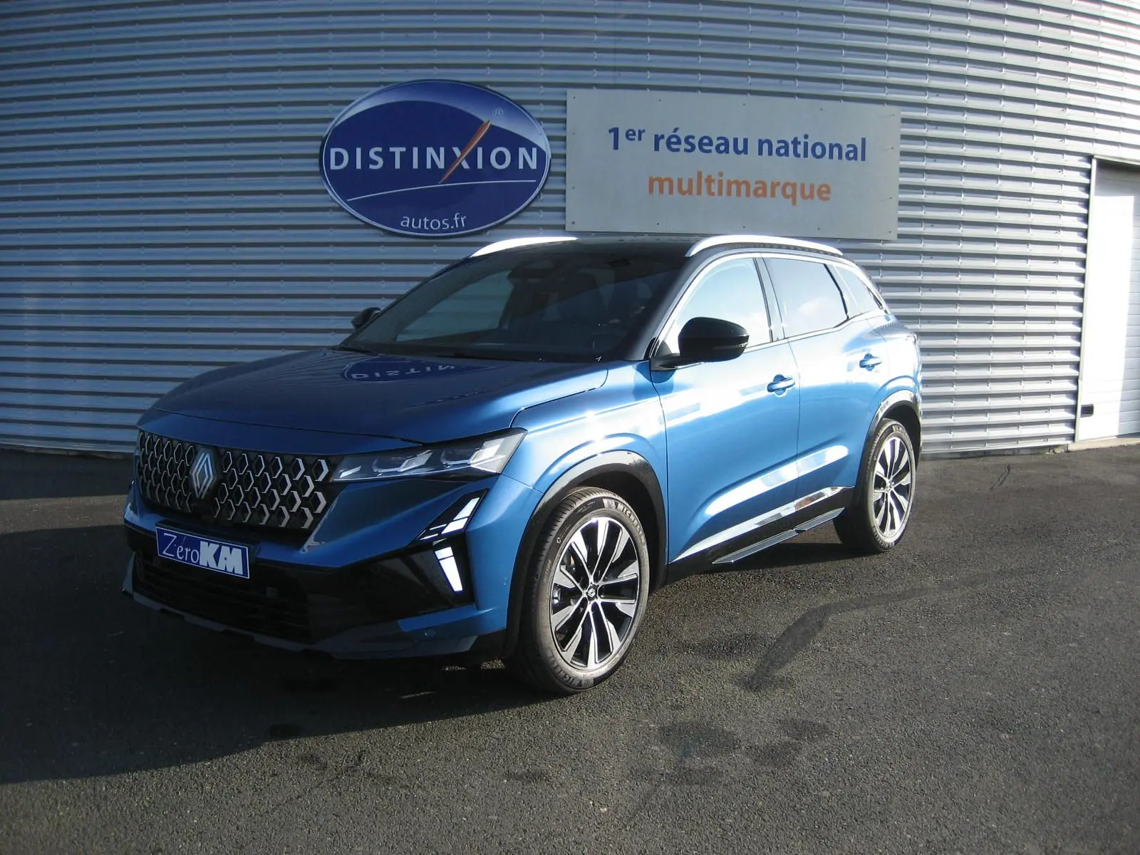 Renault Austral 2025 bleu outremer avec toit noir, vue 3/4 avant droit, calandre distinctive et jantes alliage.