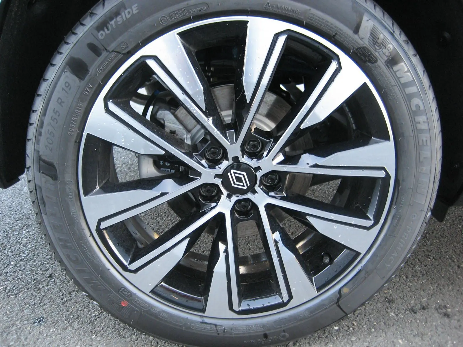 Gros plan sur la jante alliage noire et argentée avec logo Renault, montée sur pneu Michelin.