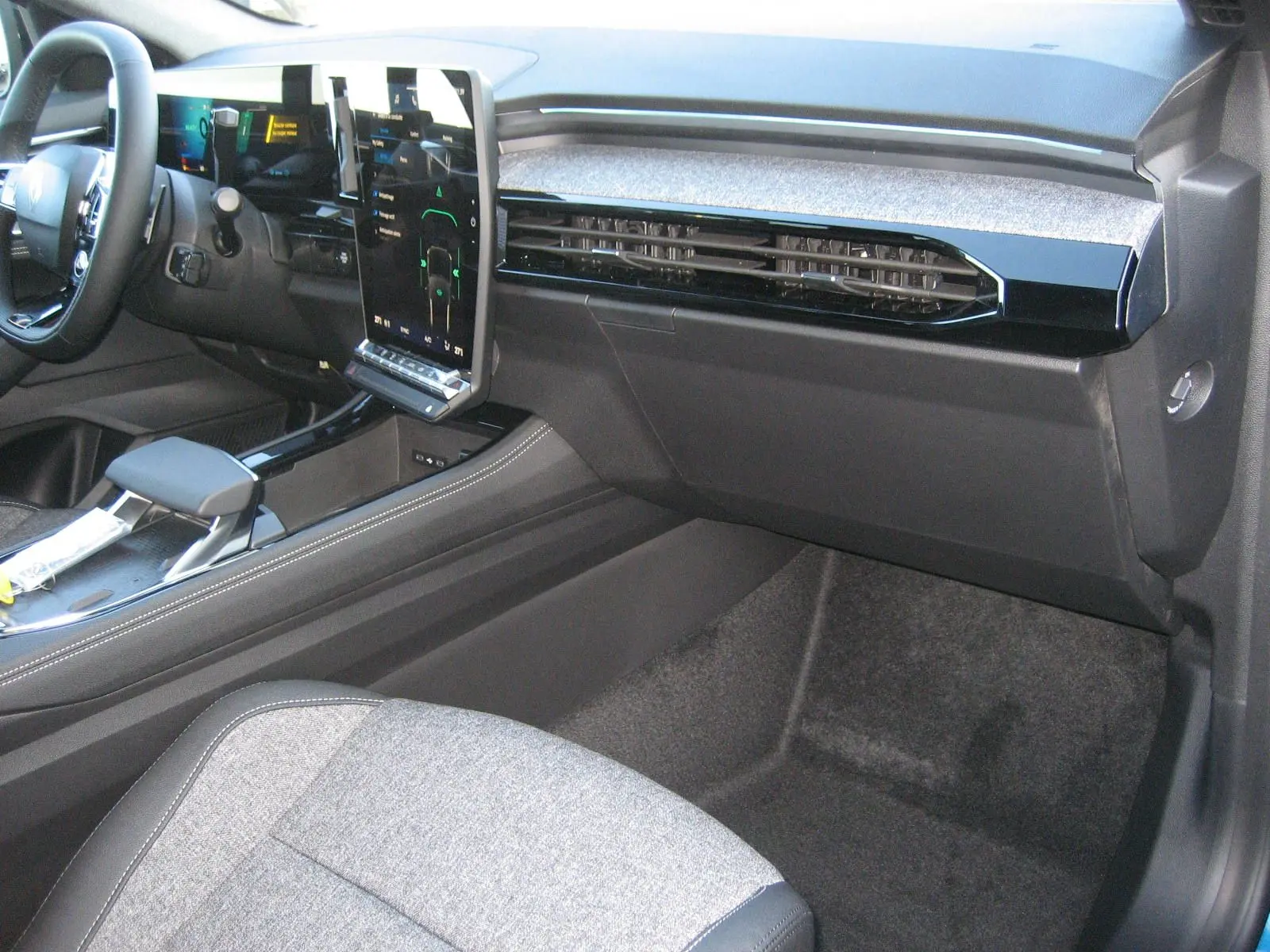 Vue intérieure côté passager du tableau de bord et console centrale du Renault Austral PH.2 avec écran tactile vertical et sellerie gris clair.