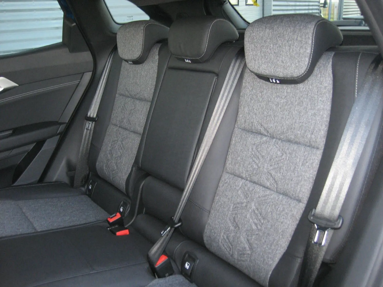 Vue intérieure sur la banquette arrière grise et noire du Renault Austral 2025 avec ceintures de sécurité visibles.