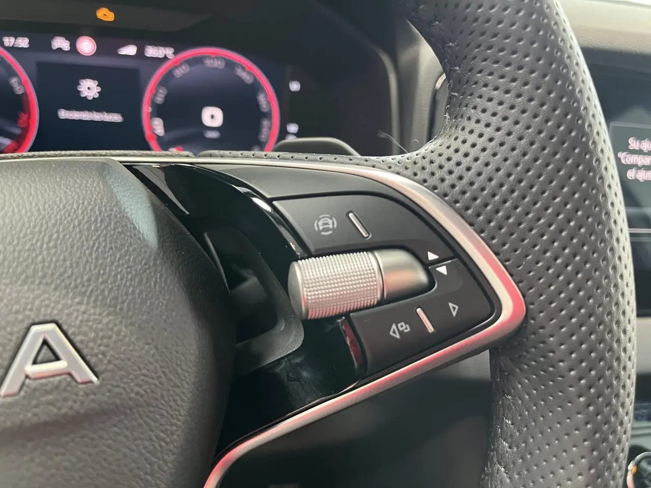 Gros plan sur les commandes multifonctions en aluminium et cuir perforé du volant du Skoda Karoq 2025.