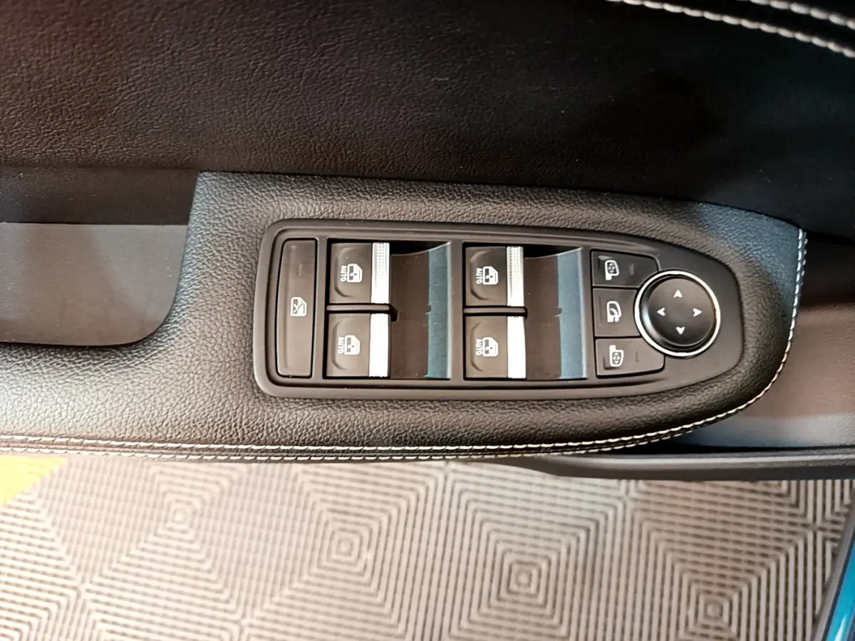 Gros plan sur les commandes des vitres et rétroviseurs côté conducteur du Renault Arkana bleu 2023, finition Techno E-Tech.