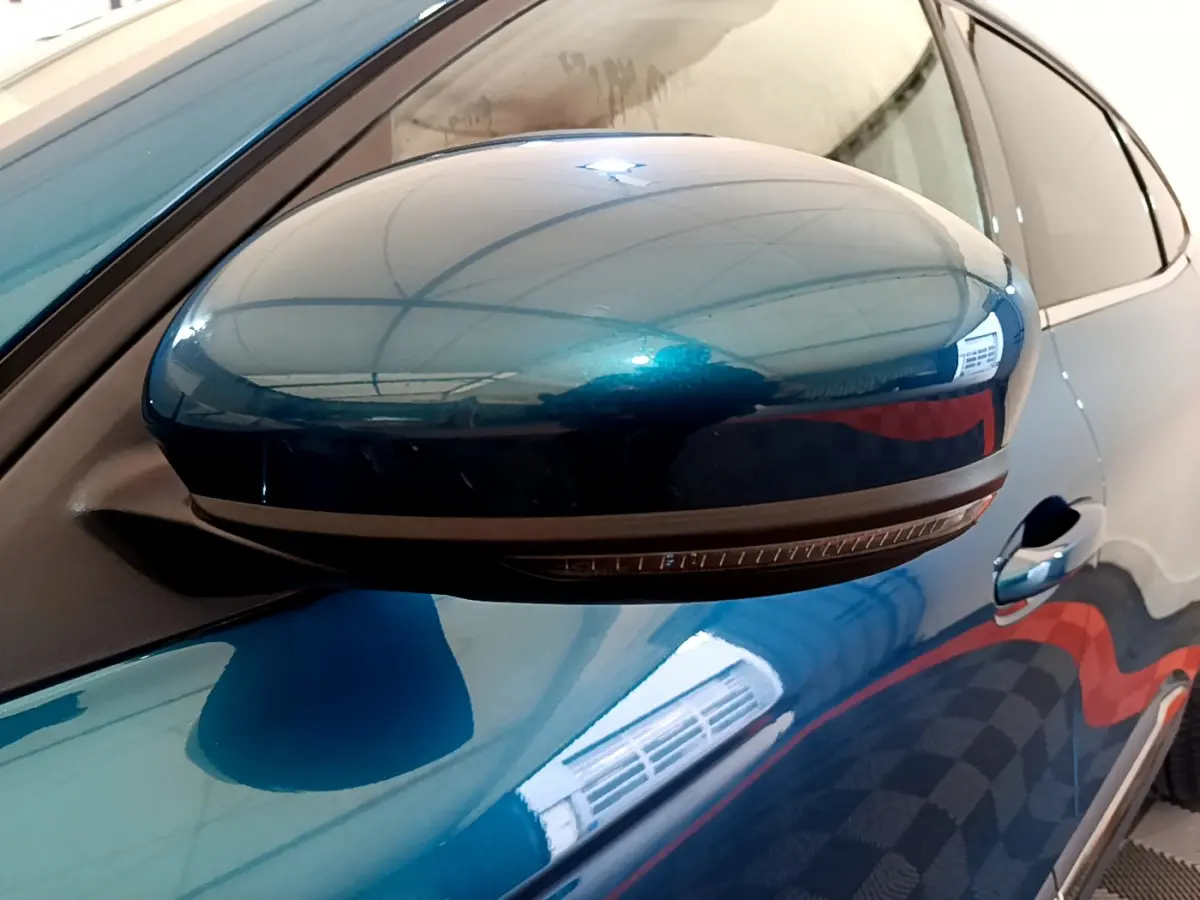 Rétroviseur côté gauche bleu métallisé de la Renault Arkana Techno E-Tech 2023 avec clignotant intégré.