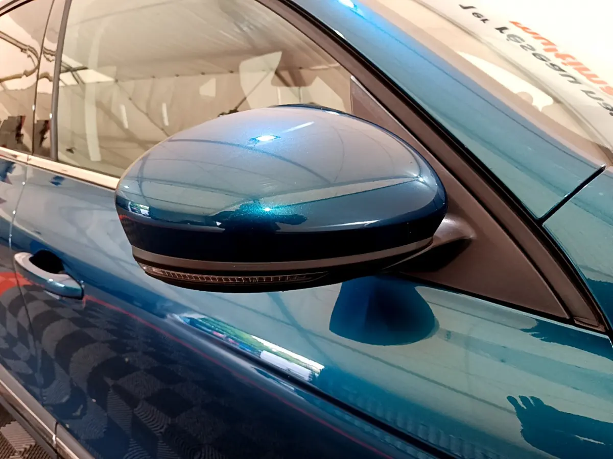 Rétroviseur côté gauche bleu métallisé de la Renault Arkana Techno E-Tech 145, vue rapprochée sur la portière.