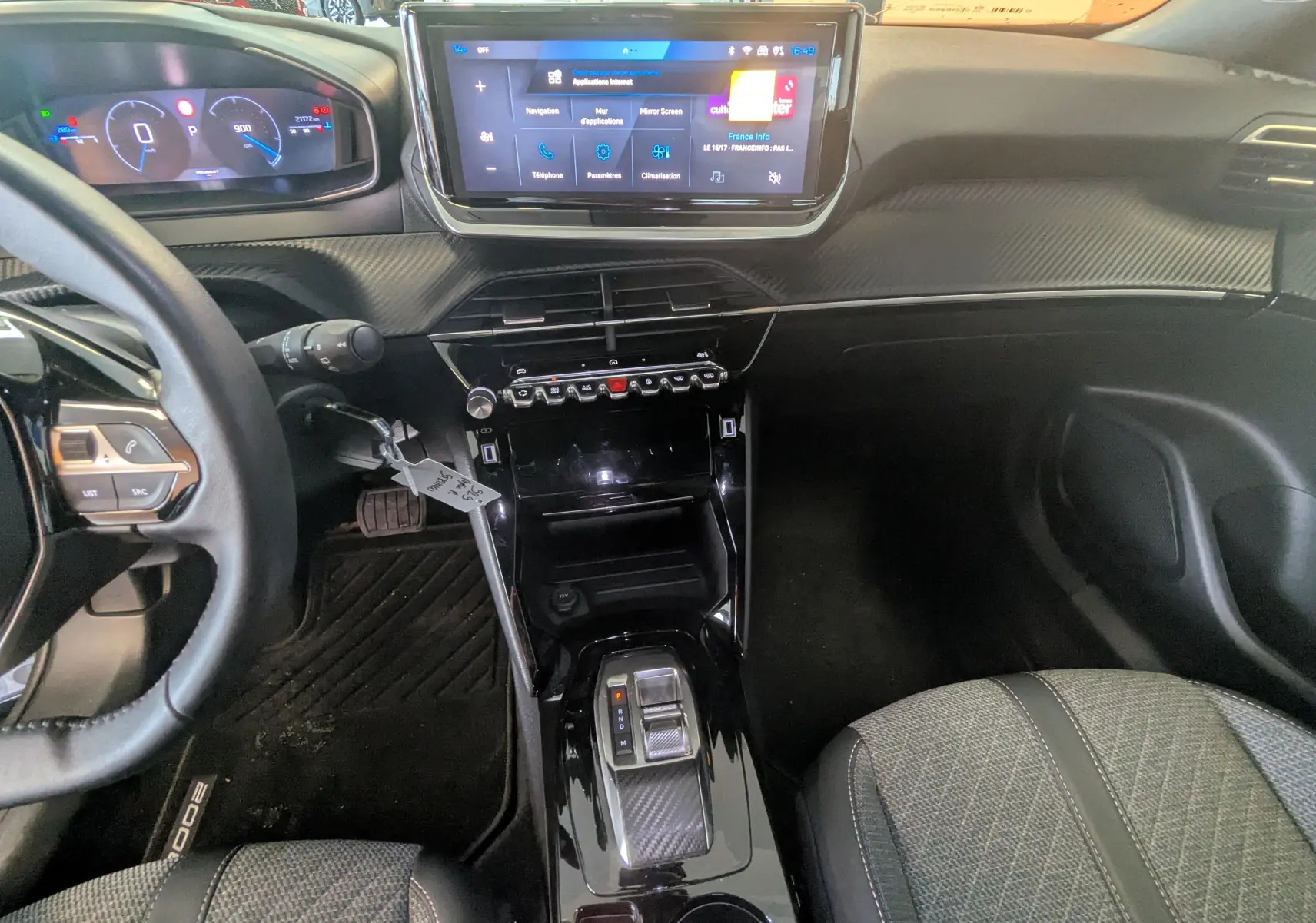 Vue intérieure avant du Peugeot 2008 noir 2024, avec tableau de bord digital, écran tactile central et console brillante.