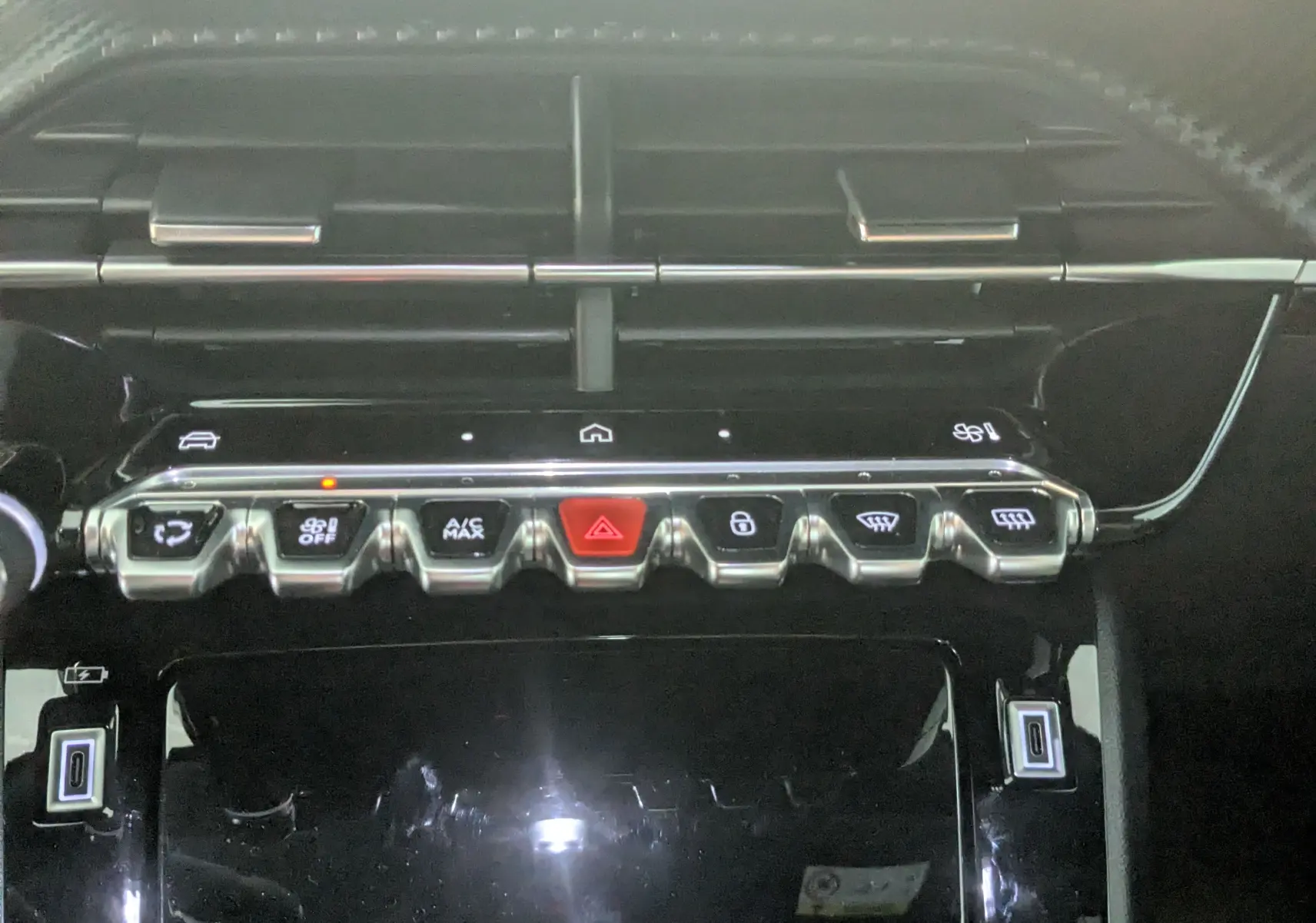 Gros plan sur la rangée de boutons de commande du tableau de bord du Peugeot 2008 noir 2024, version 130ch eat8 allure.