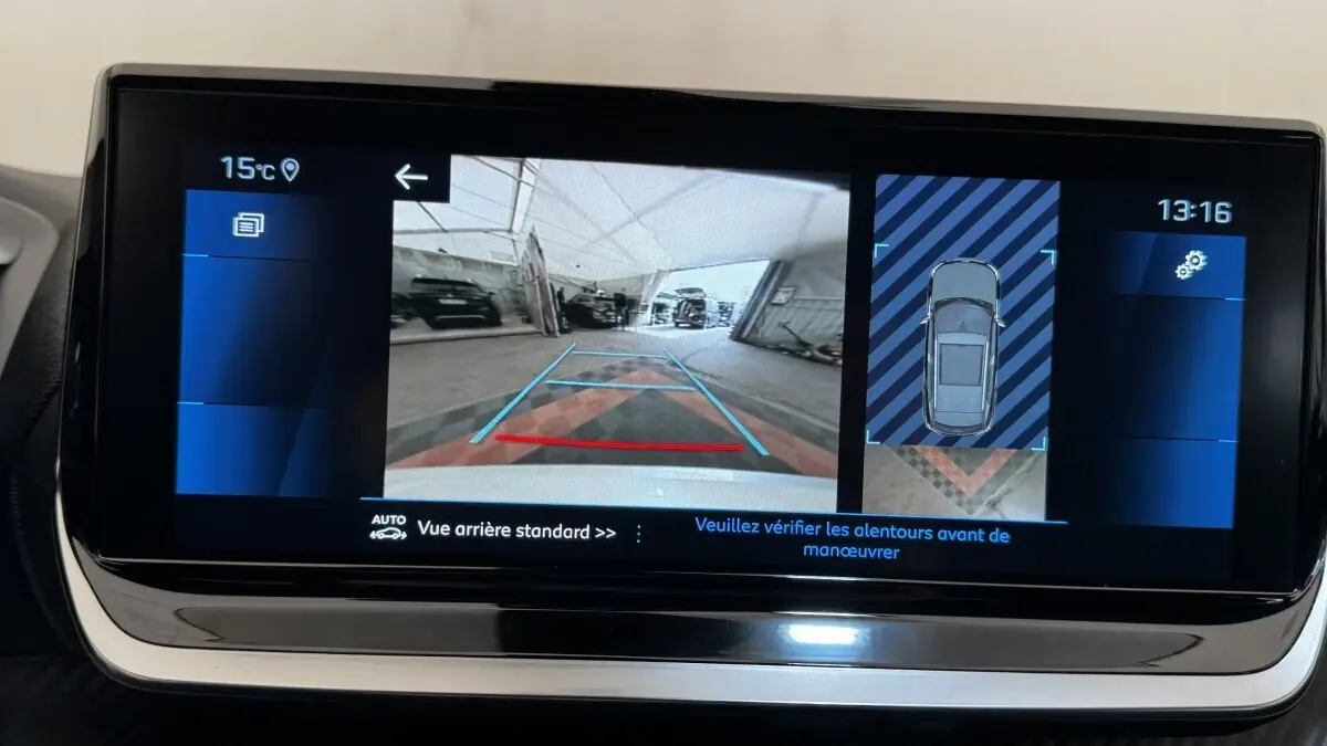 Écran tactile du tableau de bord montrant la caméra de recul et l'affichage 360° du Peugeot 2008 gris foncé.