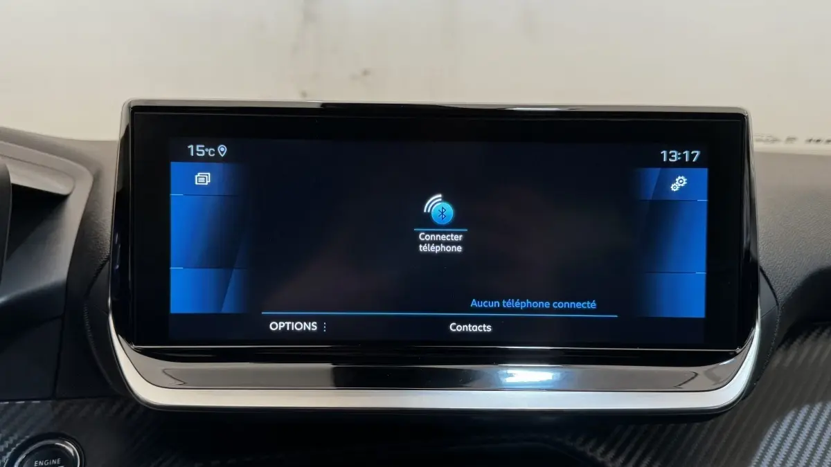 Écran tactile central du tableau de bord du Peugeot 2008 gris foncé, affichant la connexion Bluetooth au téléphone.