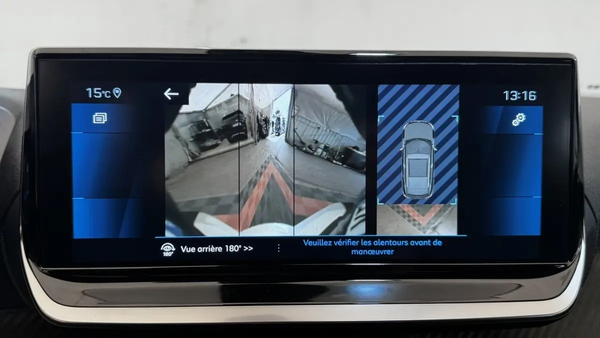 Écran tactile intérieur du Peugeot 2008 gris foncé montrant la caméra de recul et l'affichage 360° du stationnement.